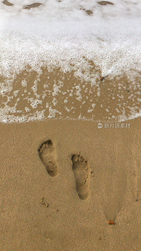 海滩脚印在潮湿的沙滩上的图像，赤脚走/光脚脚趾在海边沿果阿喀拉拉邦海滩，印度海岸线海，在夏天低潮的海浪，足迹足迹带领一个人走在印度海滩度假